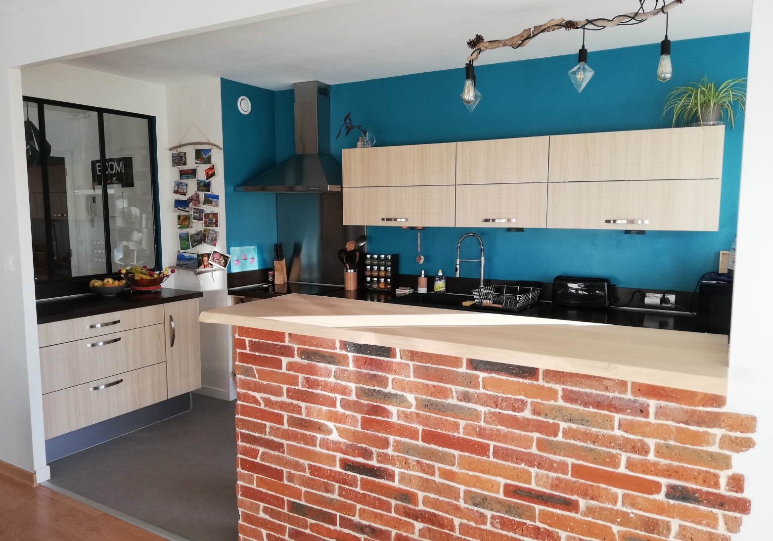Cuisine modernisée avec mur bleu canard et bar